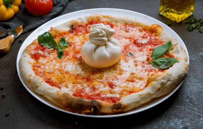 Burrata cheese is a fresh Italian cheese made of cream and mozzarella. the outer shell is a fine layer of mozzarella. Meanwhile, the inside has a creamy cream-like filling. It is usually served warm and chilled
