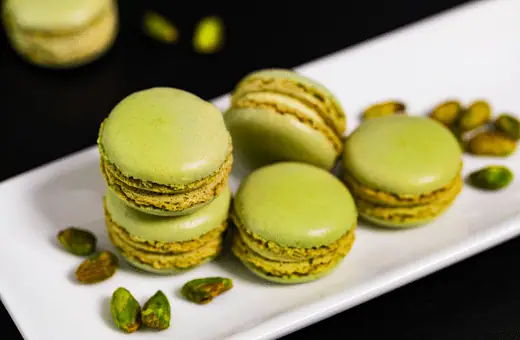 pistachio macarons delicate French cookies are made with almond flour and filled with a rich, creamy pistachio filling. The result is a sweet, nutty, and utterly delicious cookie.